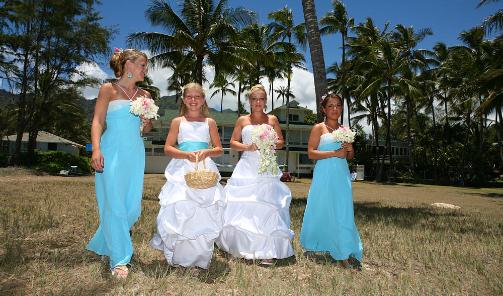 angela and her bridesmaids walking to their wedding on the beach in AHwaii