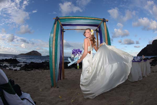 Jenna posing after her Hawaiian wedding close to sunset
on the beach under her gazebo