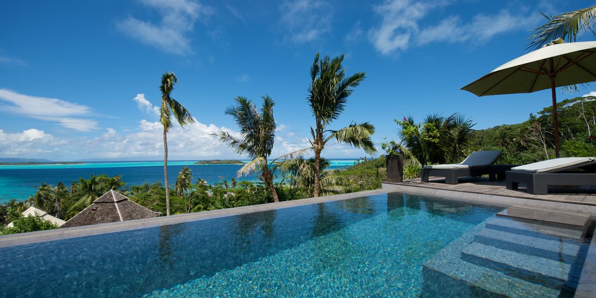 Infinity pool at the estate house overlooking the ocean and palm trees