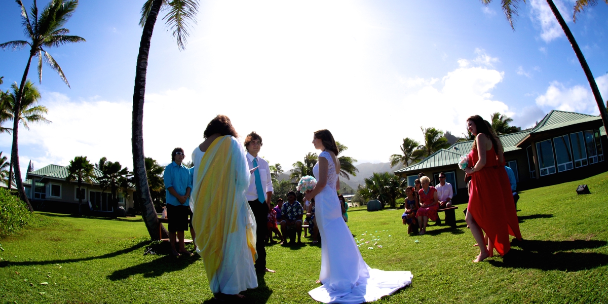 Bride and groom standing on the lawn with guests during their garden ceremony
