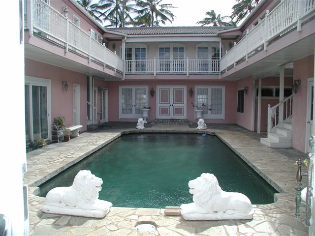 Courtyard pool at the pink house with two white lion statues
