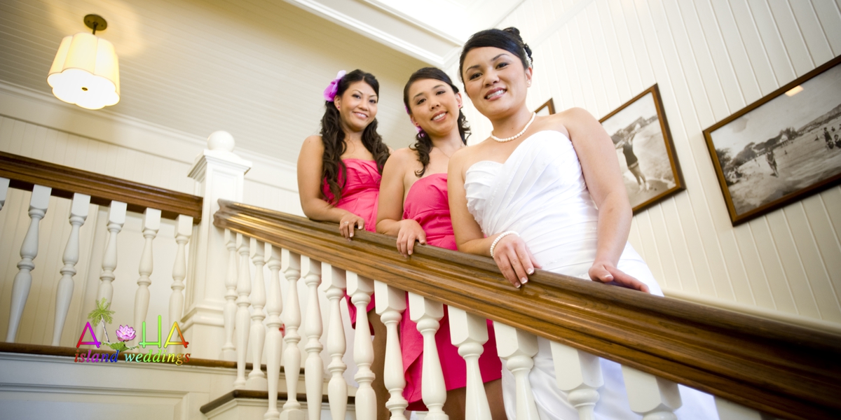 Bride and bridesmaids in pink on a staircase inside the hotel