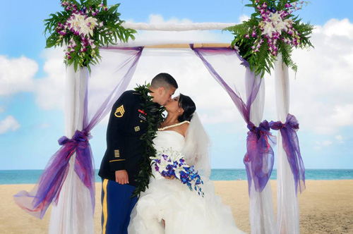 Stevie and Jon kissing under their wedding arch