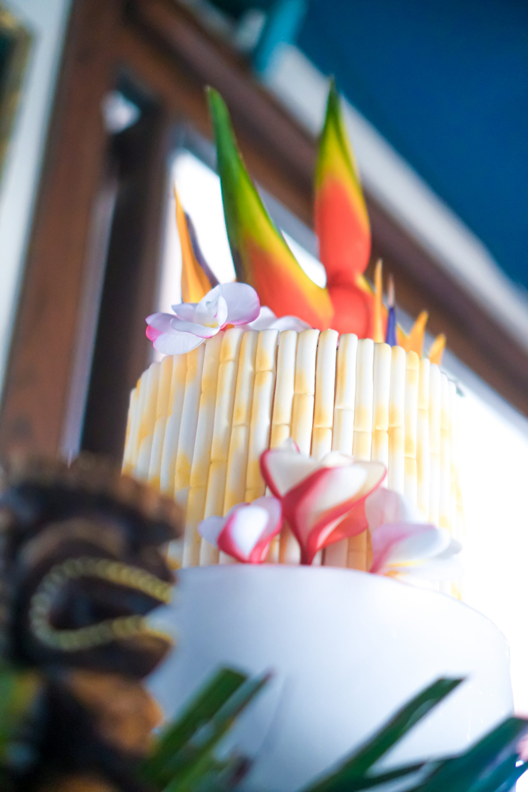 Tiki wiki Hawaiian wedding cake by aloha island Weddings with bamboo rolled fondant and Hawaiian tropical flowers of plumerias and birds of paradise