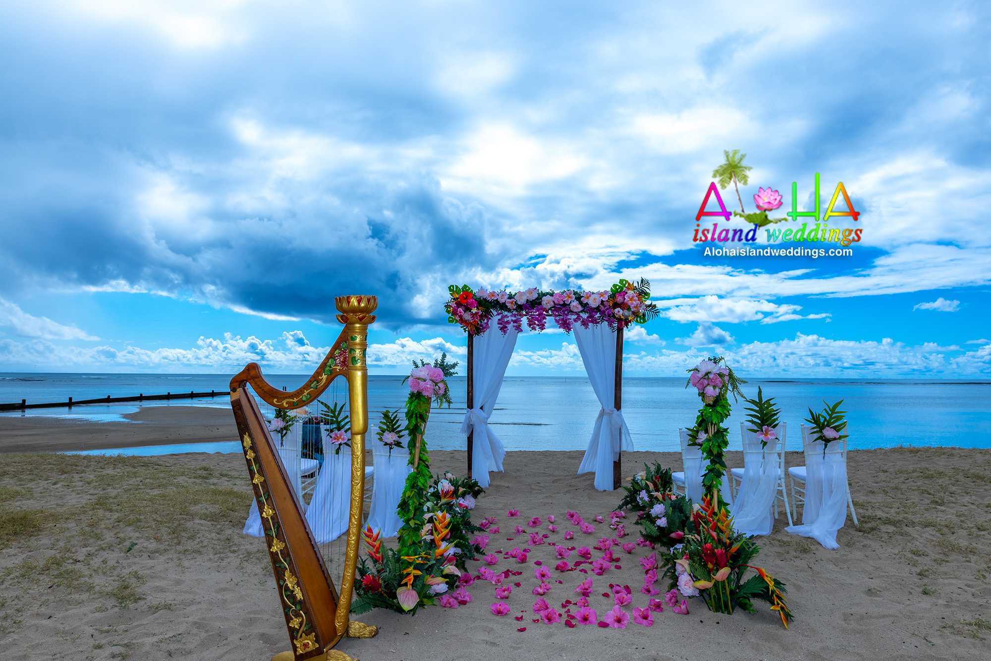 Golden Renaissance harp in Hawaii awaits for the wedding to begin on the beach of Oahu , Tropical Hawaiian florals line the pathway