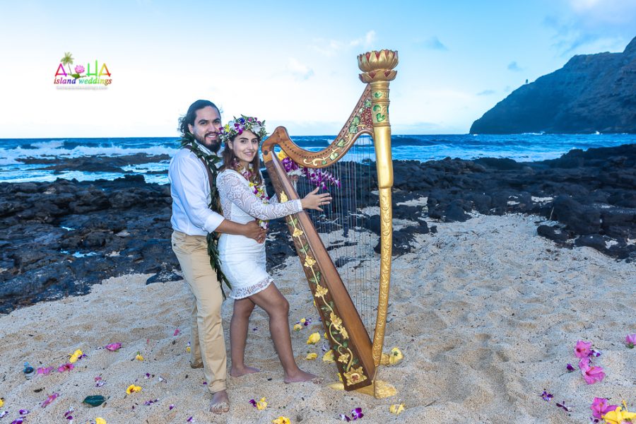 Bride pretends to play the harp at Makapuu beach in Hawaii