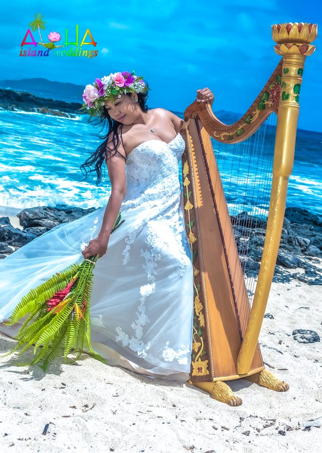 Hawaii bride holds the harp with lei po'o Crown of flowers adorning her head